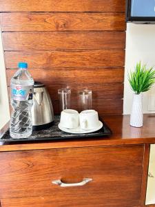 a counter with a tray with a bottle of water and cups at Utk 3 in Panchkula