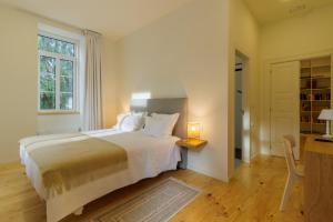 a white bedroom with a bed and a window at Quinta da Janeca in Vila Pouca de Aguiar