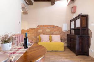 a living room with a yellow couch and a brick wall at Il Poggiarello in Chianni