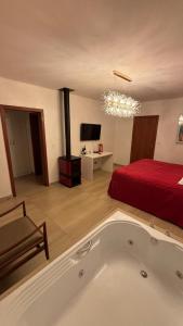 a room with a bath tub and a bed at BANGALÔS REFÚGIO DO VALE in Santa Maria do Erval