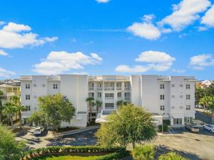 an apartment building with a blue sky in the background at The Alexander in Rosemary Beach