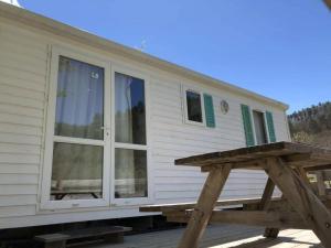 a tiny house with a large sliding glass door at Camping 3 étoiles - Piscine - ccbgccf in Rennes-les-Bains