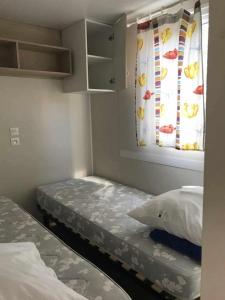 a small room with two beds and a window at Camping 3 étoiles - Piscine - ccbgccf in Rennes-les-Bains