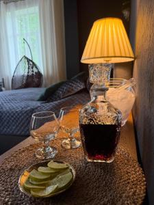 a table with a lamp and two glasses and a plate of pickles at Viesnīca Meirānu Muiža in Meirāni +69 photos