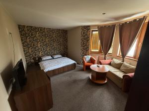 a bedroom with a bed and a couch and a table at Penzión Sunflower in Piešťany