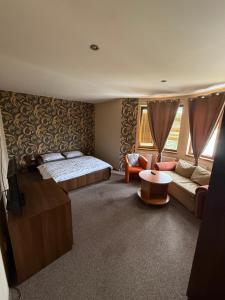 a bedroom with a bed and a couch and a table at Penzión Sunflower in Piešťany