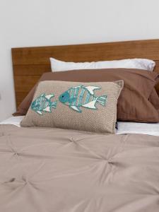 a bed with a pillow with a fish on it at aliseo in Olbia