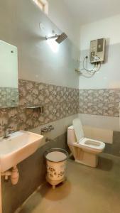 a bathroom with a sink and a toilet and a mirror at Khushi Homestay Hampi in New Hampi +25 photos