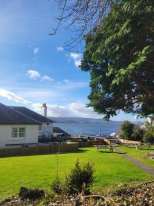 a park with a view of the water and a house at North Kessock Hotel in Inverness