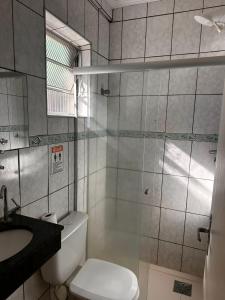 a bathroom with a shower and a toilet and a sink at Pousada Saturnino in Hortolândia