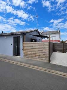 a house with a wooden fence in front of it at Le Studio, proche du puy in Saint-Pierre-Montlimart