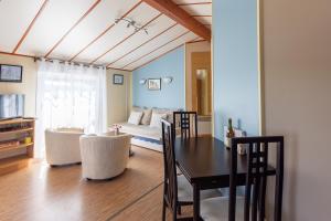 a living room with a table and a couch at Le Chalet 67, vue Lac Guerlédan & Accès Direct à l'Eau in Caurel