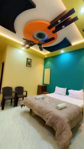 a bedroom with a large bed with a ceiling fan at Khushi Homestay Hampi in New Hampi