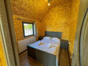 una piccola camera da letto con un letto in una parete gialla di Nirok a Sevan