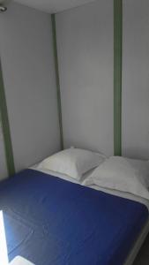 a bed with a blue sheet and white pillows at Camping 3 étoiles - Piscine - ccbfihb in Casaglione