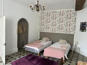 two beds in a room with a purple rug at Chambre d'hôtes - demeure historique in Chantenay-Saint-Imbert