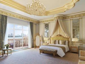 a large bedroom with a bed and a chandelier at Raffles The Palm in Dubai +247 photos