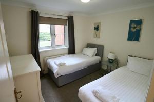 a hotel room with two beds and a window at Bracknell Spacious Two Bedroom Apartment in Bracknell