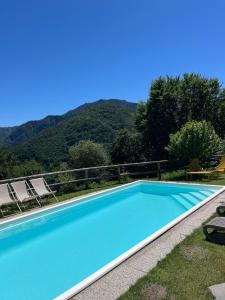 a large blue swimming pool with mountains in the background at Casa Europa in Ledro