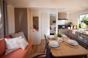 a kitchen and a dining room with a table and a couch at Camping 2 étoiles - Piscine - ccbgb0d in Sospel