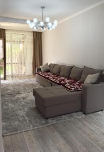 a living room with a couch and a chandelier at Коттедж в Азиа Палас in Chon-Sary-Oy