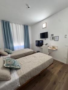 a bedroom with two beds and a desk in it at aliseo in Olbia