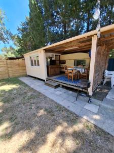 a house with a patio with a table and chairs at Côté plage in Vias