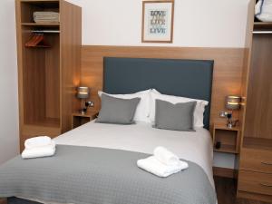 a bedroom with a bed with two towels on it at All Seasons B&B in Portrush