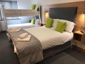 a bedroom with two bunk beds with green pillows at All Seasons B&B in Portrush +8 photos