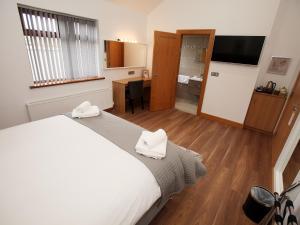a bedroom with a large bed with white towels on it at All Seasons B&B in Portrush
