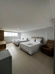 a room with two beds and a chair in it at Danny's Hotel in Tailandia