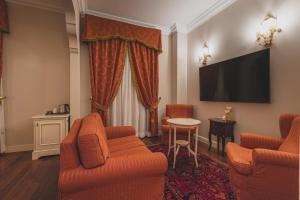 a living room with two chairs and a tv at Hotel Villa Il Patriarca in Chiusi