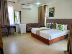 a bedroom with a bed and a couch in a room at Cycad Palm Hotel in Gaborone +29 photos