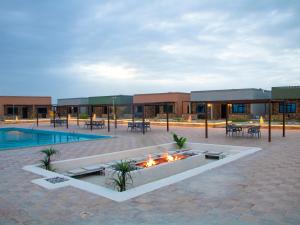 a courtyard with a fire pit in front of a building at Roushan Resort Salalah Mirbat in Mirbāţ