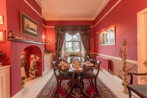 a red dining room with a table and a fireplace at challan hall in Silverdale +30 photos