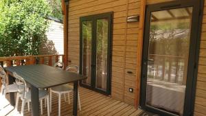a wooden deck with a table and chairs on it at Camping 2 étoiles - Piscine - ccbfiif in Avignon