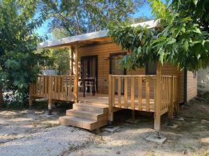a small wooden cabin with a porch and a table at Camping 2 étoiles - Piscine - ccbfiif in Avignon