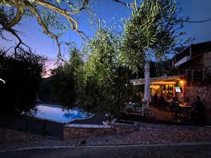a swimming pool in front of a restaurant at night at Diogenis Parga Studios in Parga