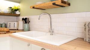 a kitchen counter with a white sink in a kitchen at Gwyndy in Beaumaris +58 photos