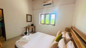 a bedroom with a white bed and a window at Safari Lodge Tempstay in Nochchiyagama