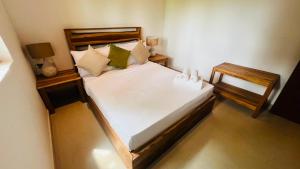 a bedroom with a large bed and two night stands at Safari Lodge Tempstay in Nochchiyagama +36 photos