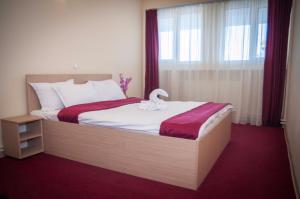 a bedroom with a bed with a swan on it at Dumbrava Minunata in Braşov