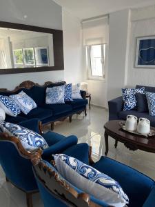 a living room with blue couches and a table at palazzo PADINI alla costa in Neoi Epivates
