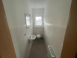 a small bathroom with a toilet and a sink at Am Wangermeer 38a in Wangerland