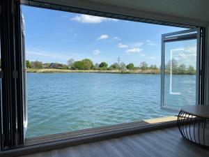a window view of a lake from a house at Hausboot Optimo mit Hund in Wangerland