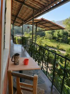 a table and chair on a balcony with a view at IntiRumi Inn in Caraz
