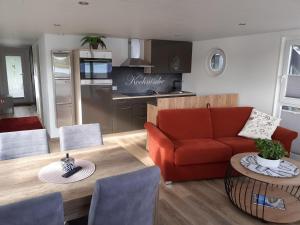 a living room with a couch and a table at Hausboot Optimo mit Hund in Wangerland