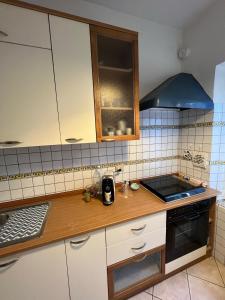 a kitchen with white cabinets and a stove top oven at Vista mare in San Vincenzo