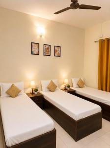 two beds in a room with two lamps on them at Elite Stays Viman Nagar in Pune
