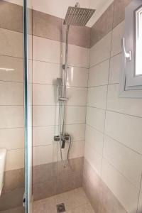 a bathroom with a shower with a glass door at Ageri Suite II in Vóthon +6 photos